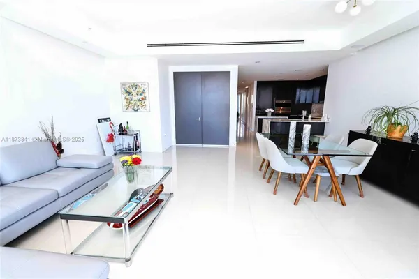 a living room with furniture and kitchen view