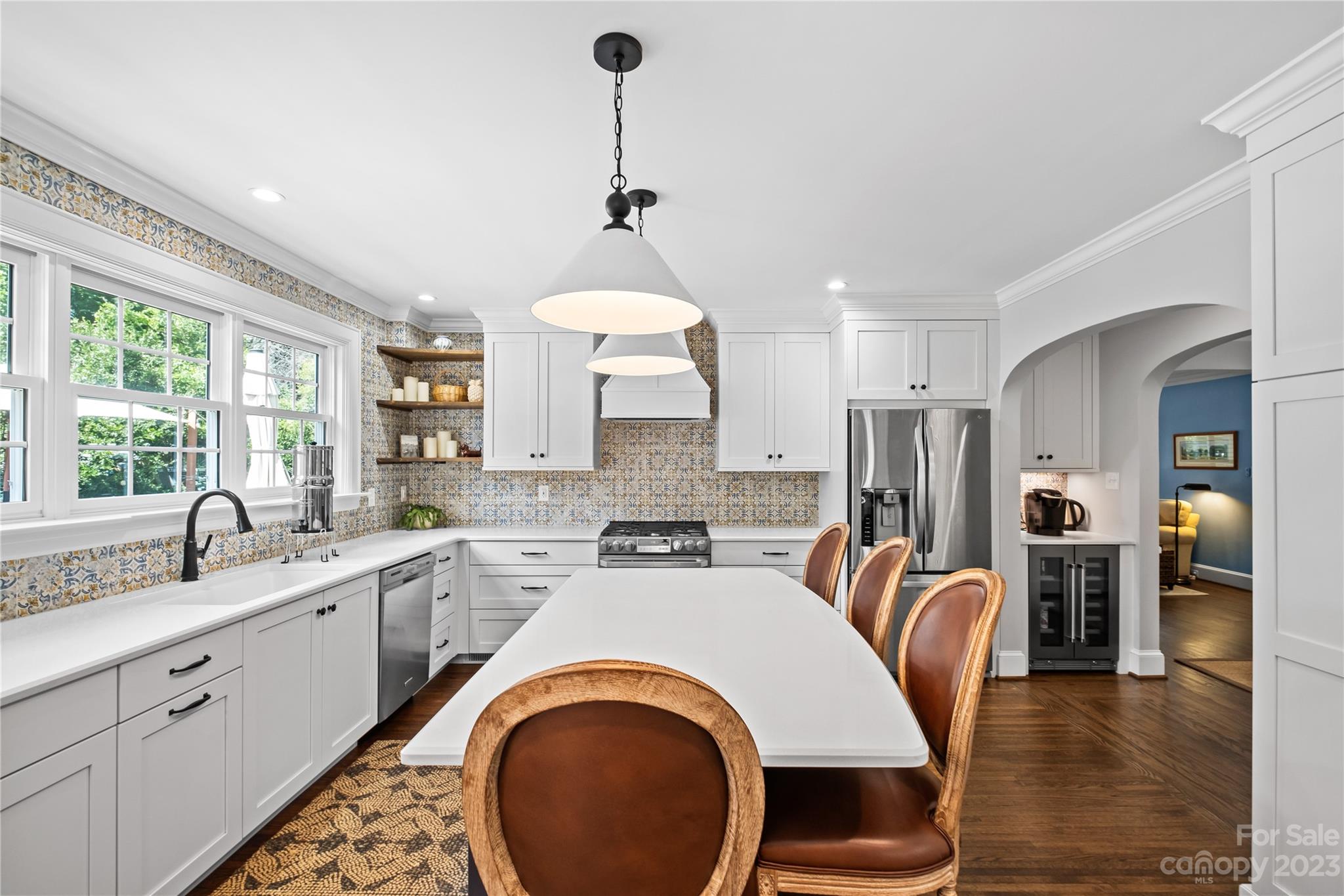 1324 Goodwin Avenue Charlotte, NC 28205 - Photo 10 of 29 a kitchen with stainless steel appliances a dining table chairs sink refrigerator and cabinets