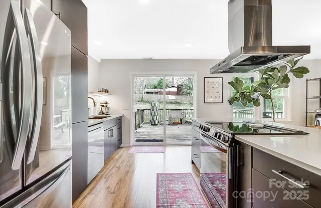 a kitchen with stainless steel appliances granite countertop a refrigerator and a stove