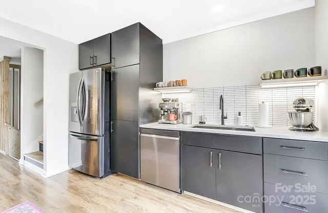 a kitchen with stainless steel appliances a refrigerator and a sink