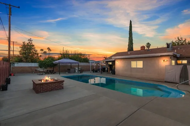 a front view of a house with a garden and lake view