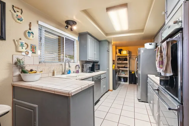 a kitchen with a sink refrigerator and cabinets