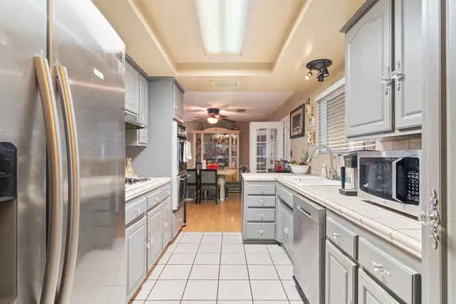 a kitchen with stainless steel appliances granite countertop a refrigerator a stove and a sink with cabinets
