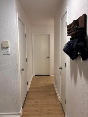 a view of a hallway with wooden floor and entryway