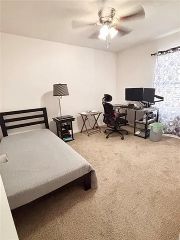 a spacious bedroom with a bed and a chandelier