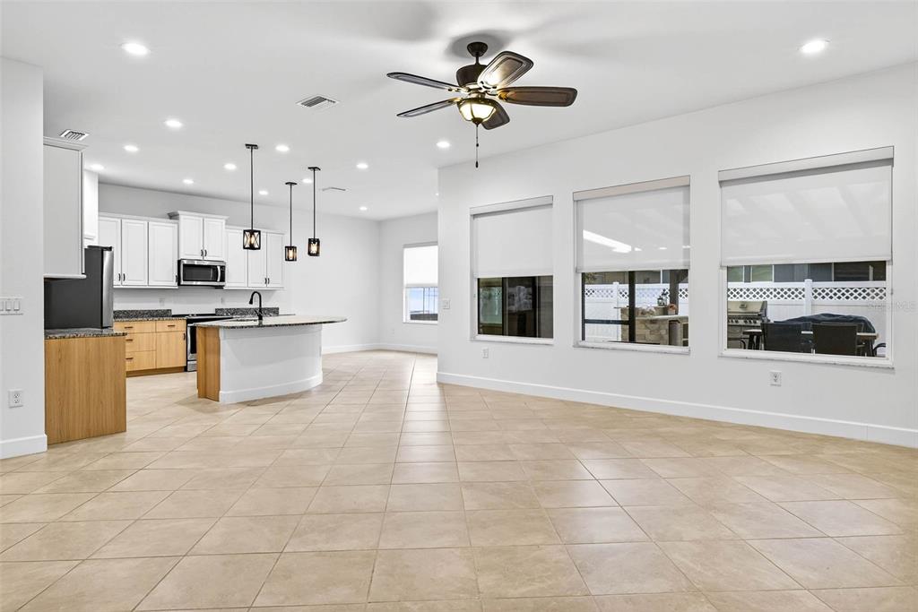 33487 Azalea Ridge Drive Wesley Chapel, FL 33545 - Photo 18 of 56 a view of kitchen with stainless steel appliances granite countertop a stove top oven a sink a counter top space cabinets and living room view