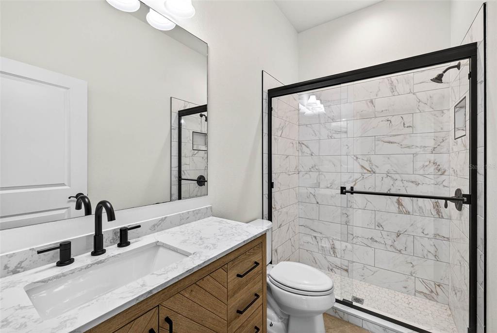 33487 Azalea Ridge Drive Wesley Chapel, FL 33545 - Photo 24 of 56 a bathroom with a granite countertop sink toilet and shower