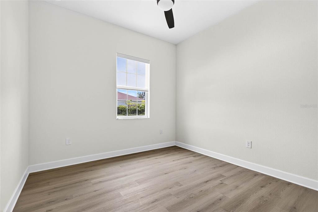 33487 Azalea Ridge Drive Wesley Chapel, FL 33545 - Photo 26 of 56 an empty room with wooden floor fan and windows