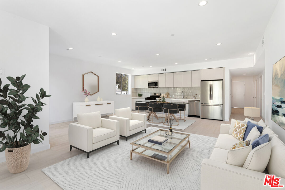 11620 Chenault Street, Unit 304 Los Angeles, CA 90049 - Photo 1 of 19 a living room with furniture potted plant and kitchen view