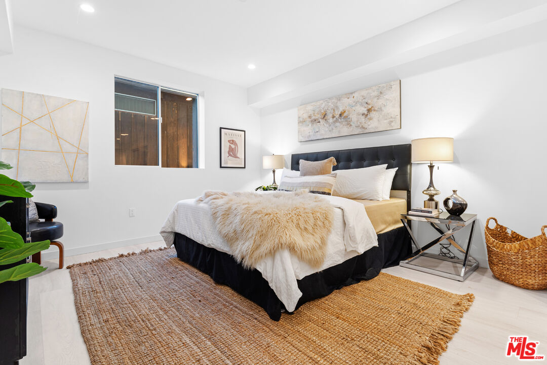 11620 Chenault Street, Unit 304 Los Angeles, CA 90049 - Photo 11 of 19 a bedroom with bed and a night stand