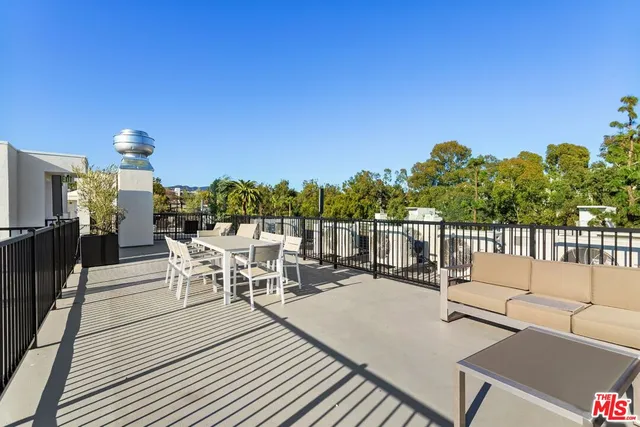 a view of a patio with a dining table and chairs with wooden floor