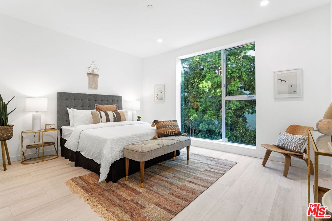 11620 Chenault Street, Unit 304 Los Angeles, CA 90049 - Photo 4 of 19 a bedroom with a bed a chair and next to a window