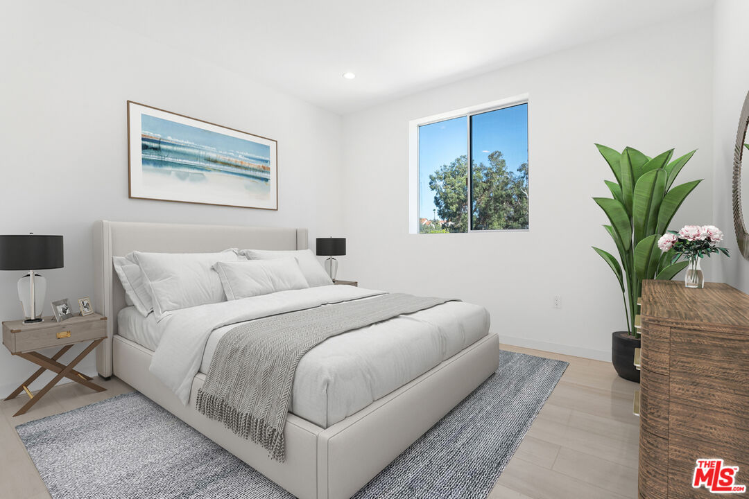 11620 Chenault Street, Unit 304 Los Angeles, CA 90049 - Photo 6 of 19 a bedroom with bed and a potted plant