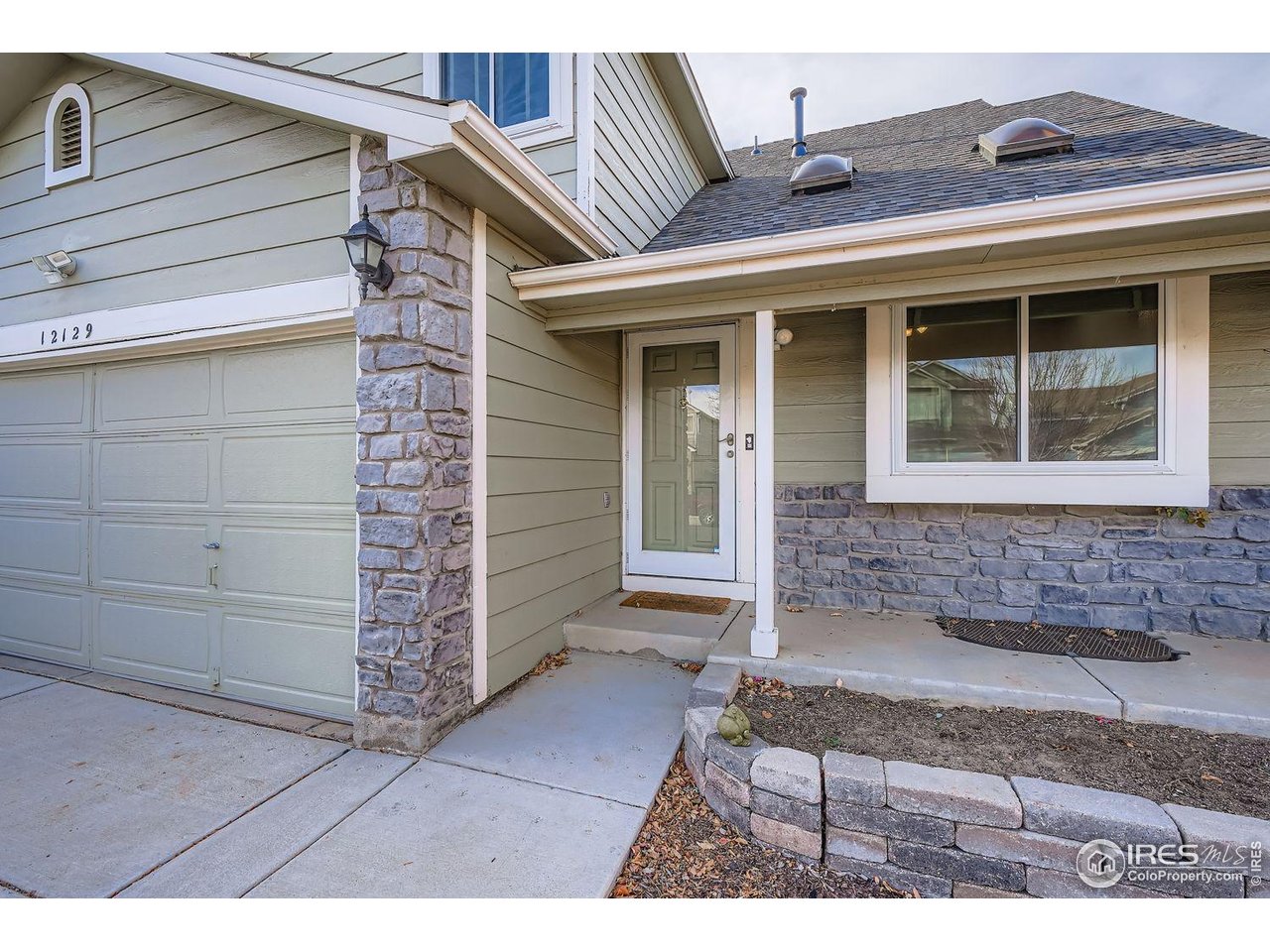12129 Forest Street Thornton, CO 80241 - Photo 2 of 19 a front view of a house with a yard
