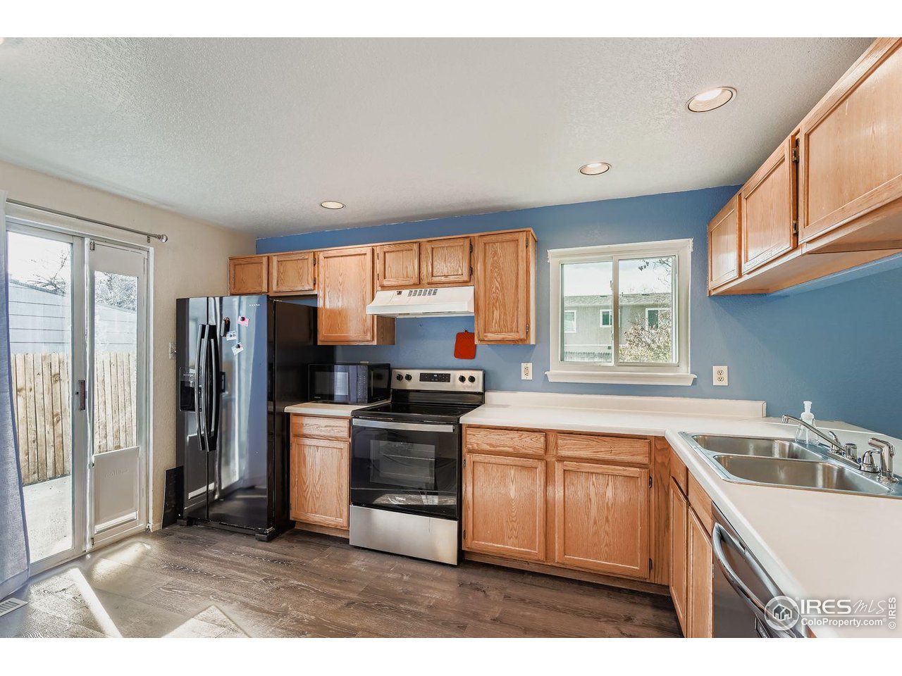 12129 Forest Street Thornton, CO 80241 - Photo 5 of 19 a kitchen with stainless steel appliances granite countertop a sink stove and refrigerator