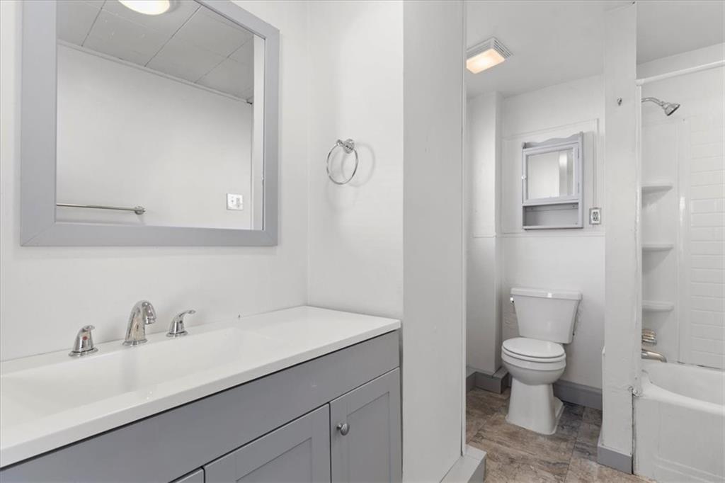 405 Walter Street Pittsburgh, PA 15210 - Photo 23 of 40 a bathroom with a granite countertop sink a toilet and a mirror