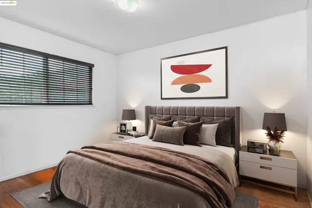 a bedroom with bed and painting on the wall