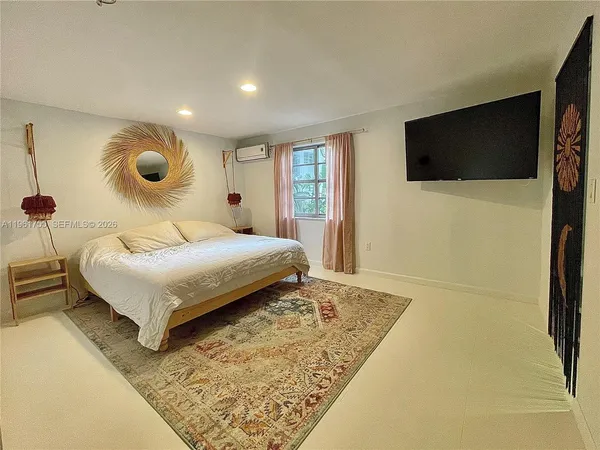 a bedroom with a bed and a lamp on dresser