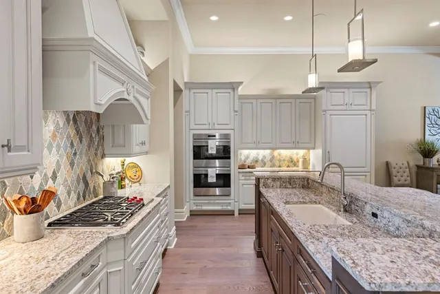 a kitchen with kitchen island granite countertop a stove and a sink