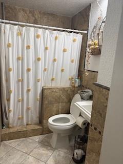 11008 Pepperidge Circle Dallas, TX 75228 - Photo 9 of 13 a white toilet sitting next to a shower curtain