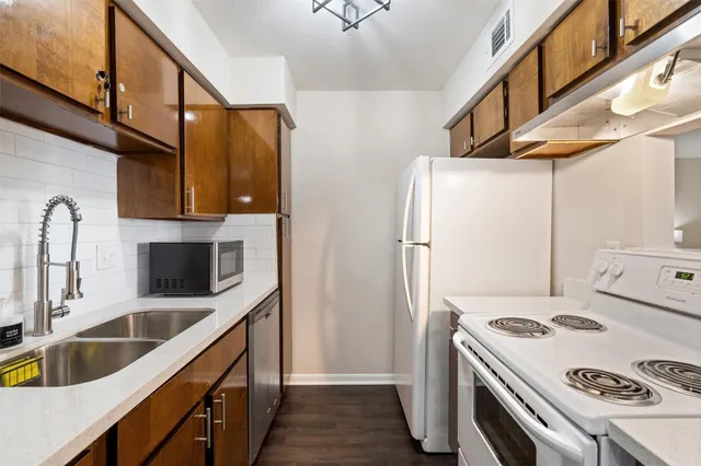 a kitchen with stainless steel appliances a stove a sink and a refrigerator