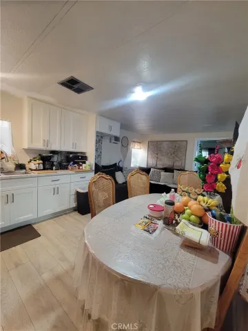 a kitchen with stainless steel appliances kitchen island granite countertop a sink a stove a dining table and chairs