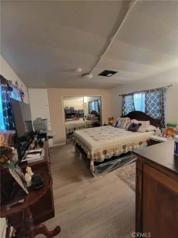 a spacious bedroom with a bed and a flat screen tv