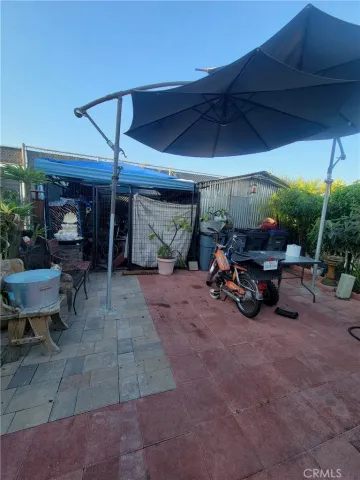 a view of a patio with table and chairs under an umbrella