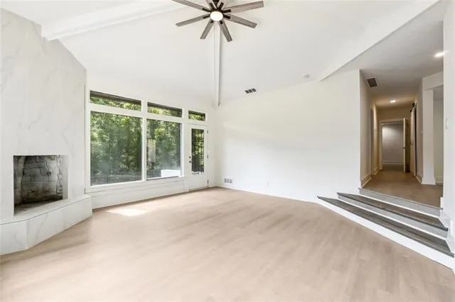 a view of an empty room with a fireplace and a chandelier