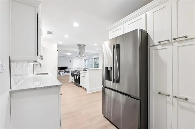 a kitchen with stainless steel appliances granite countertop a refrigerator and a sink
