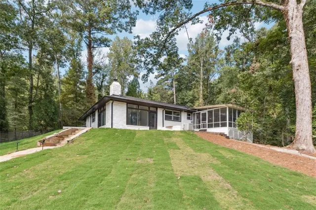 a view of a house with backyard and trees