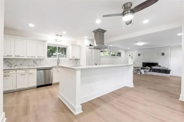 an open kitchen with kitchen island white cabinets and stainless steel appliances