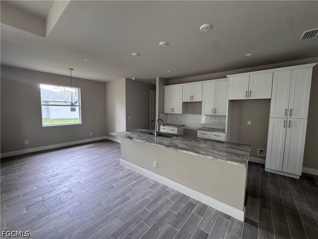 915 Marconi Loop LaBelle, FL 33935 - Photo 3 of 6 a large kitchen with stainless steel appliances granite countertop a large counter top a sink and a dishwasher
