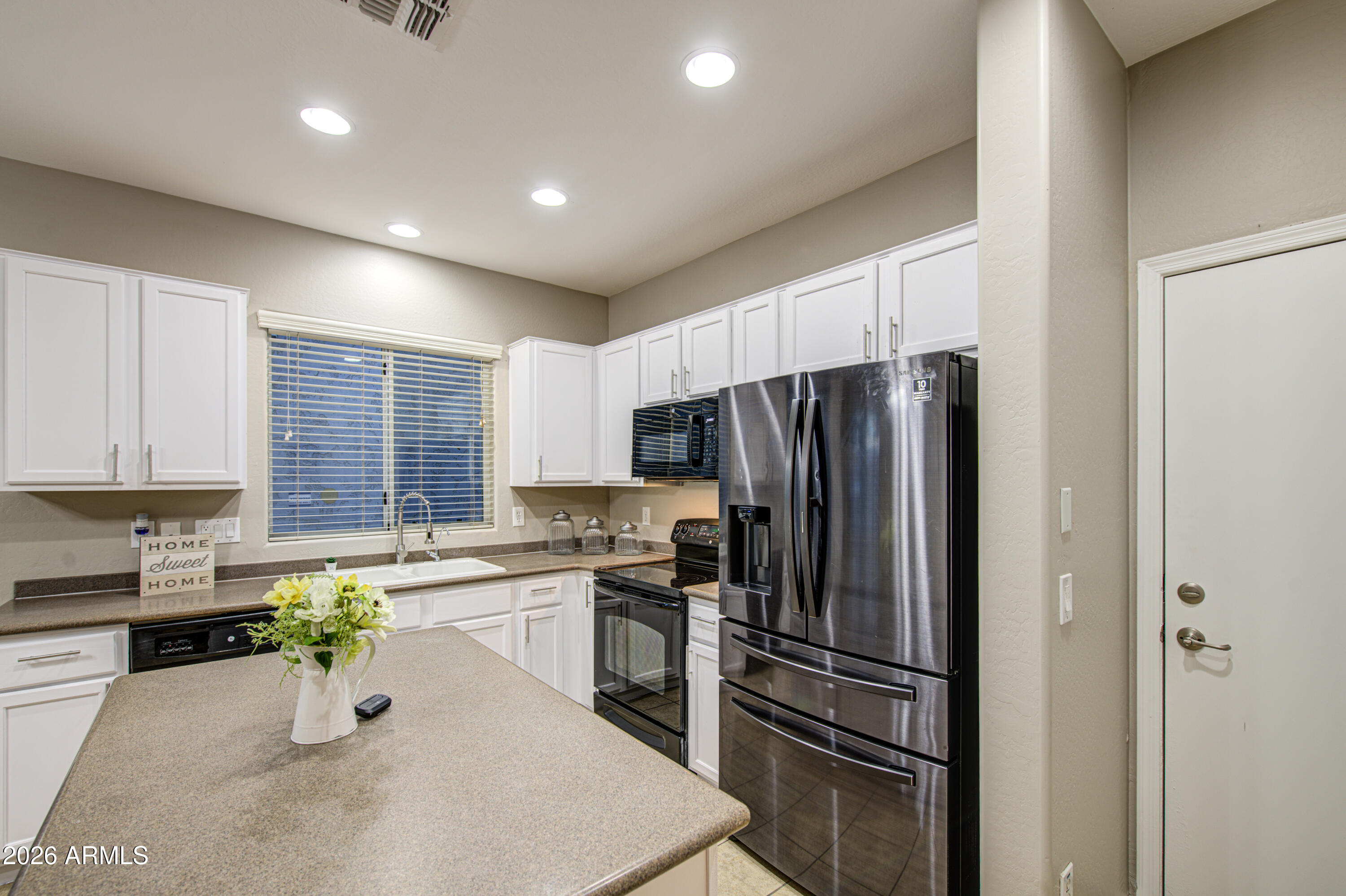 7759 West Monte Vista Road Phoenix, AZ 85035 - Photo 17 of 43 a kitchen with a refrigerator and a sink