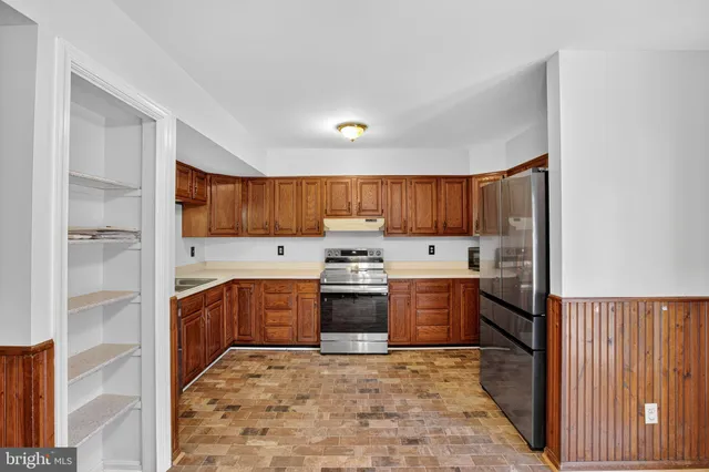 a large kitchen with stainless steel appliances granite countertop a stove and a refrigerator