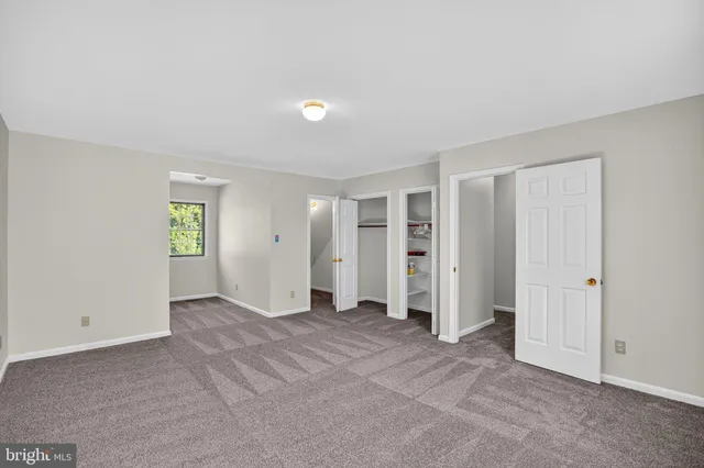 an empty room with closet and windows