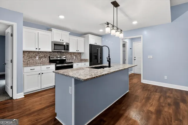 a large kitchen with stainless steel appliances granite countertop a stove and a refrigerator