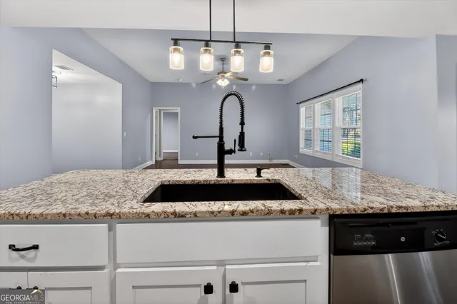 a kitchen with a granite countertop sink and wooden floor