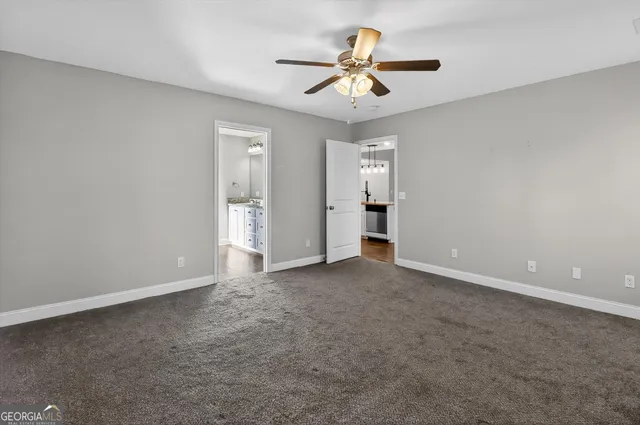 an empty room with a ceiling fan and a window