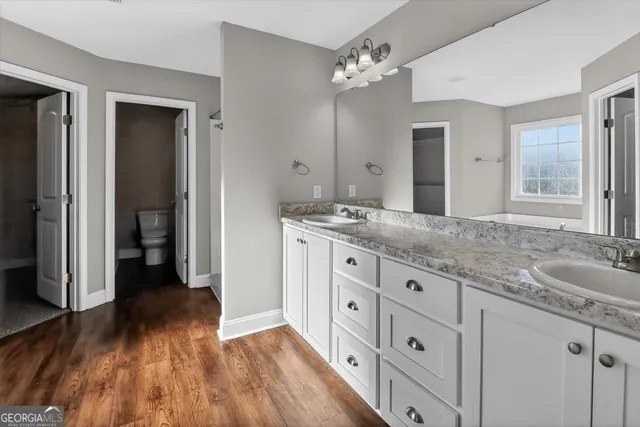a spacious bathroom with a granite countertop sink mirror and