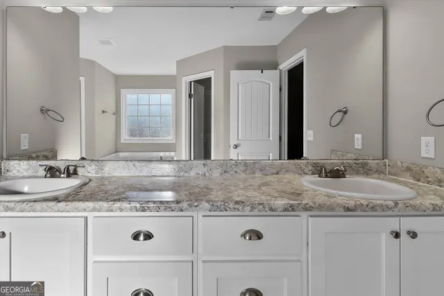 a bathroom with a granite countertop sink and a mirror