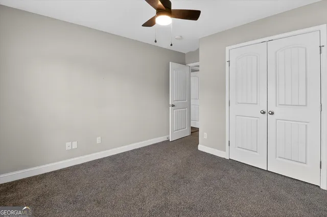 an empty room with chandelier fan