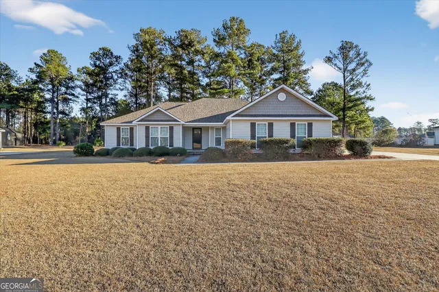 a front view of a house with a yard and trees