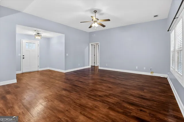a view of a room with wooden floor and a ceiling fan