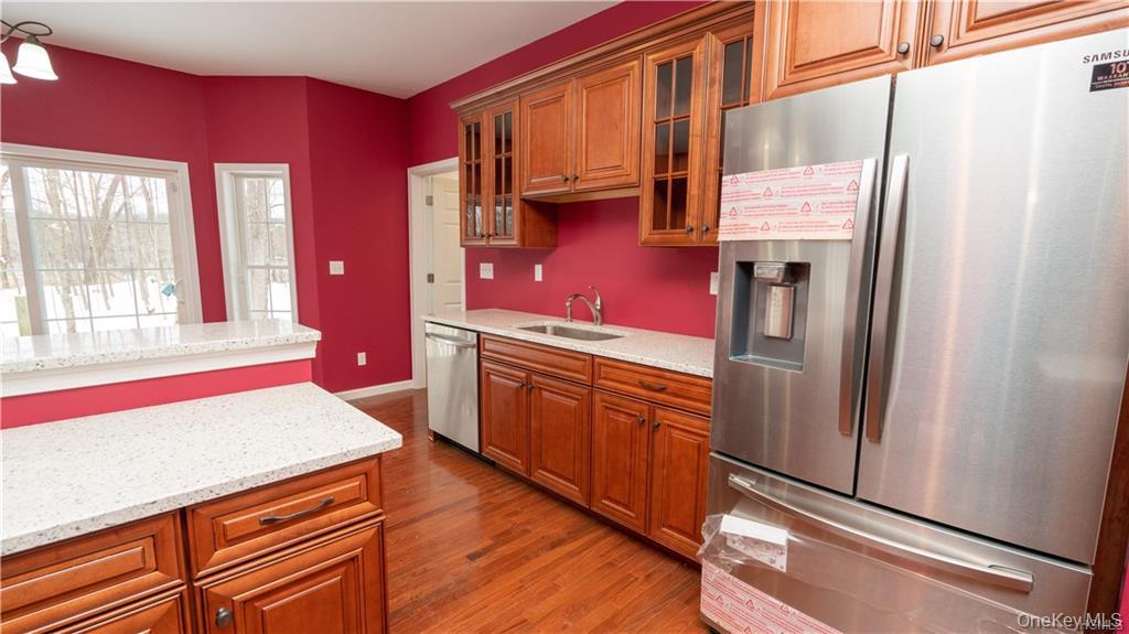 5 Harrier Ridge Drive Wallkill, NY 12589 - Photo 4 of 33 Kitchen with stainless steel appliances, glass insert cabinets, brown cabinets, and light stone counters