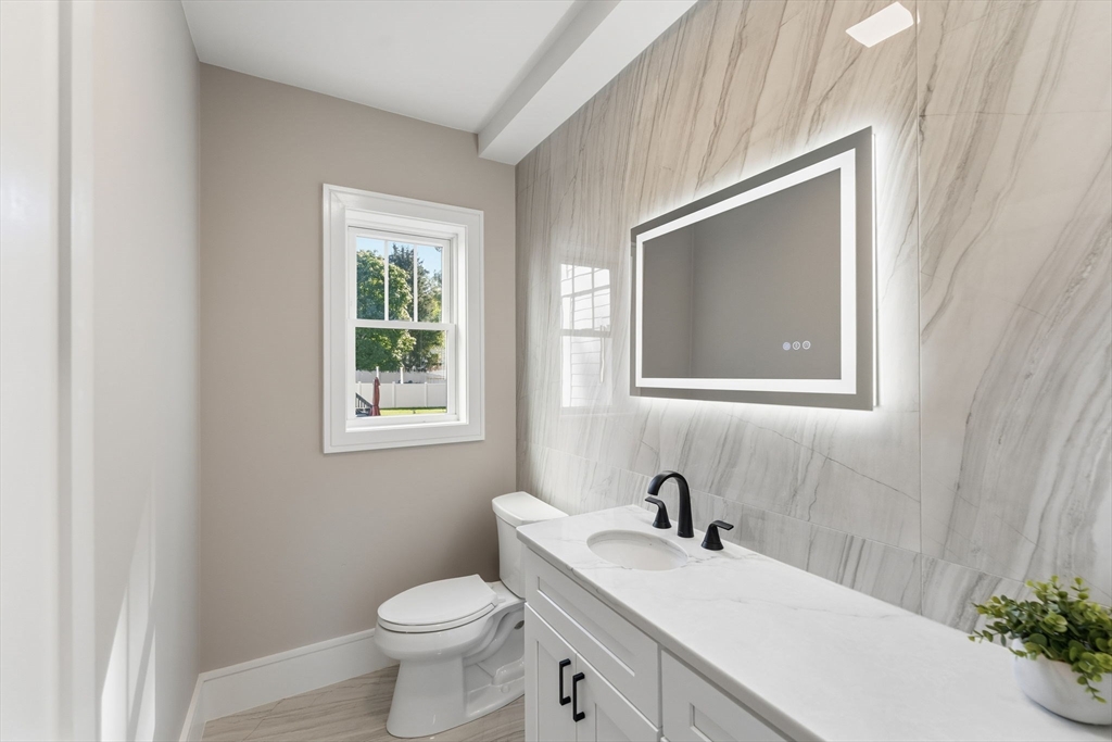 143 Hunting Road Needham, MA 02494 - Photo 20 of 42 a bathroom with a toilet sink vanity and mirror
