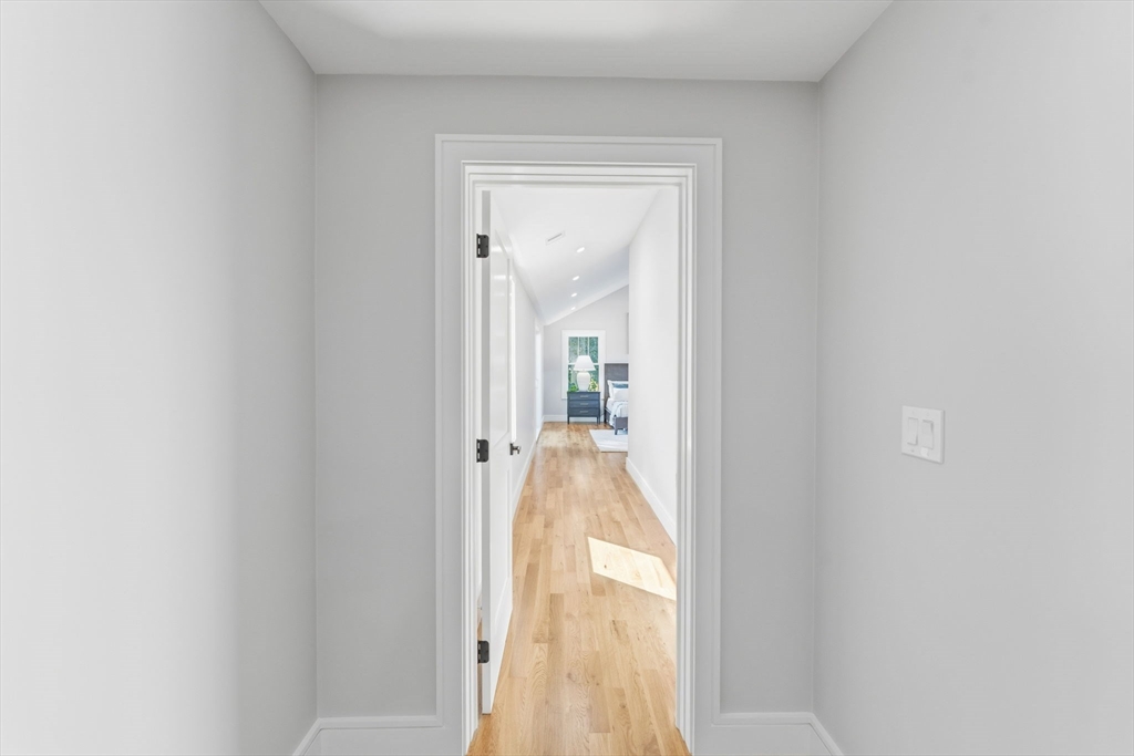 143 Hunting Road Needham, MA 02494 - Photo 22 of 42 a view of a hallway with wooden floor and a bathroom