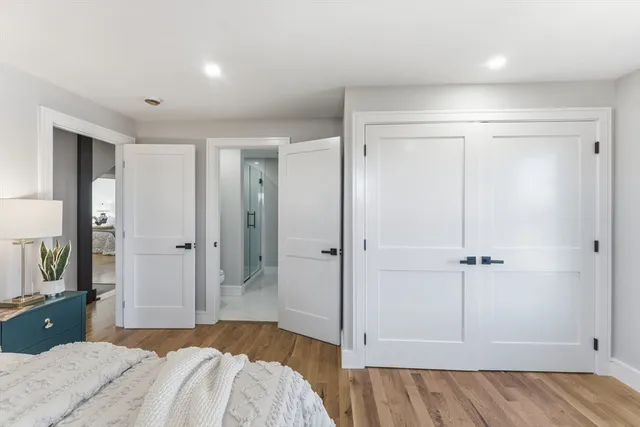 a bedroom with a large bed and wooden floor