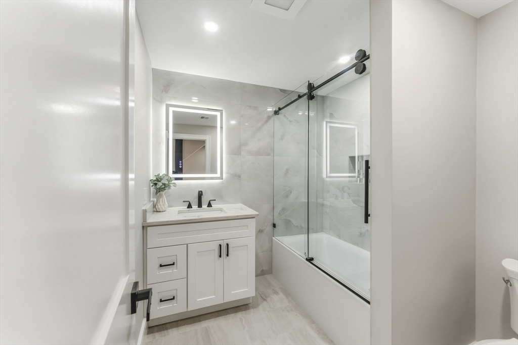 143 Hunting Road Needham, MA 02494 - Photo 32 of 42 a bathroom with a shower sink and mirror