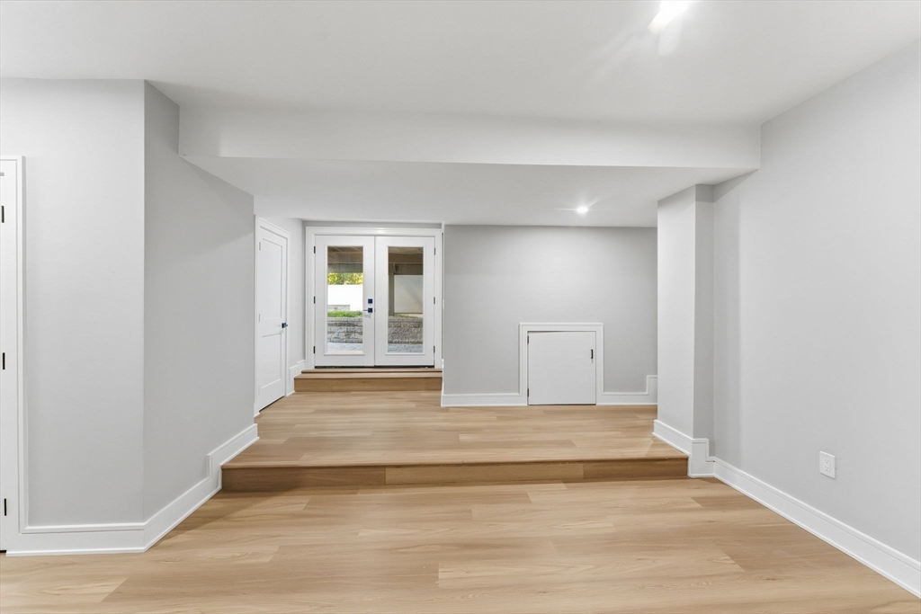 143 Hunting Road Needham, MA 02494 - Photo 38 of 42 a view of an empty room with wooden floor and a window